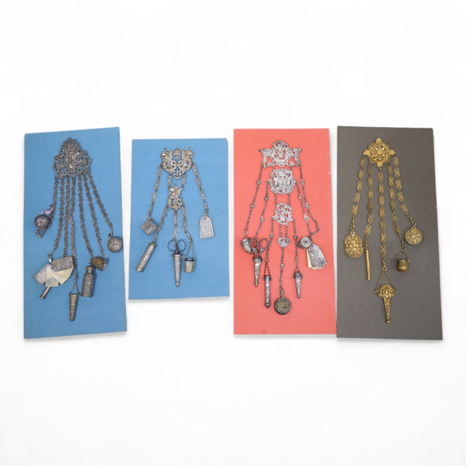 Four assorted 19th century base metal chatelaines, one with some silver implements